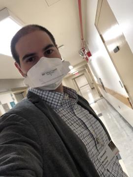 Rabbi Michael Perice wearing medical mask and name tag in hospital hallway
