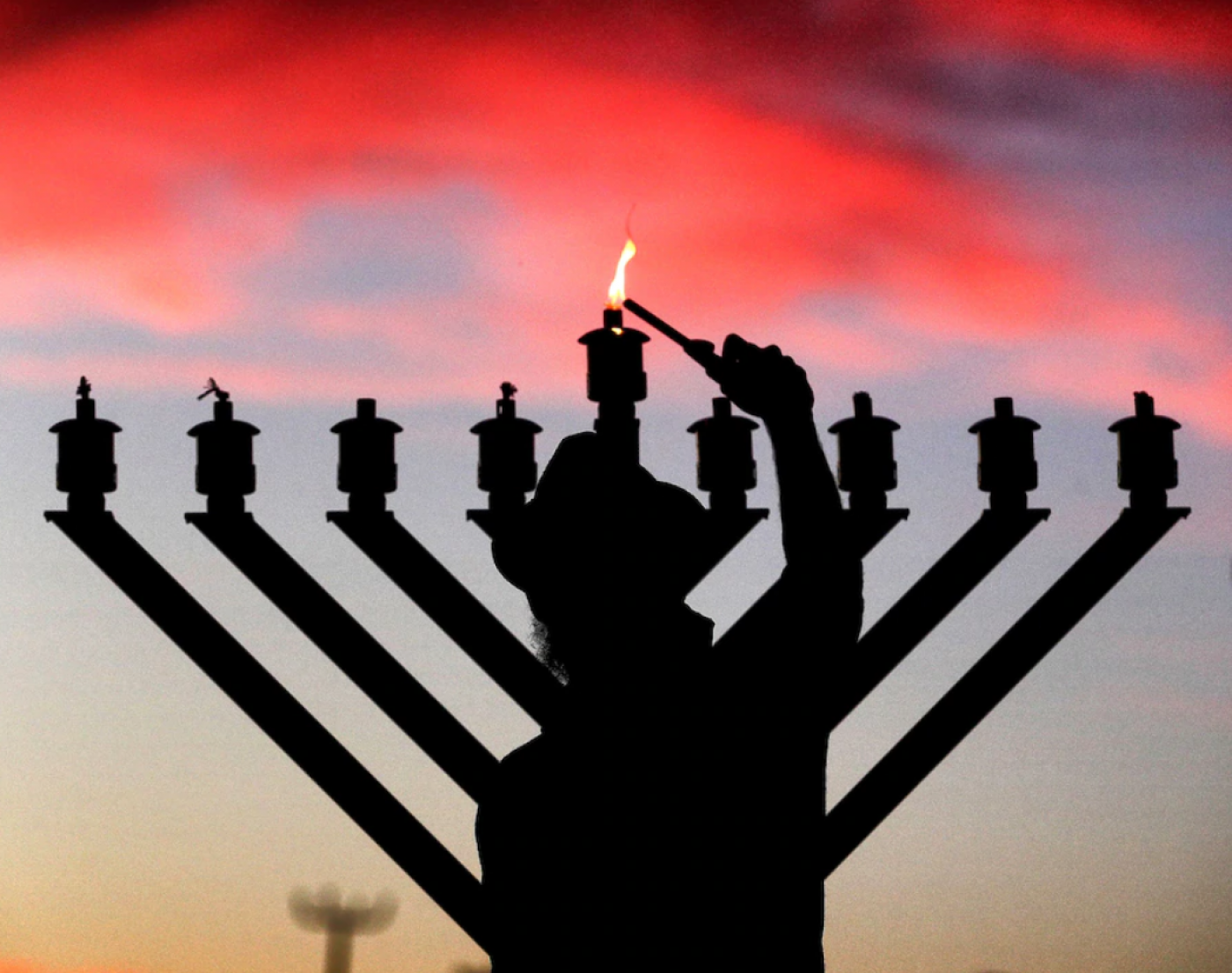 Rabbi Tzviky Dubov lights a menorah in Maitland, Fla., on Thursday. (Joe Burbank/Orlando Sentinel/AP)