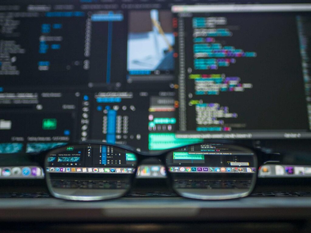 glasses in front of a computer screen with code