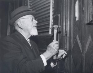 Rabbi Mordecai Kaplan affixing a mezuzah to the doorpost of the RRC building at Broad Street during the dedication ceremony of the College, October 13, 1968.