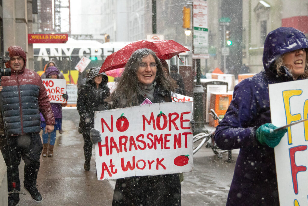 Rabbi Marissa Elana James demonstrates in the snow in Center City Philadelphia carrying a sign that reads "no more harassment at work."