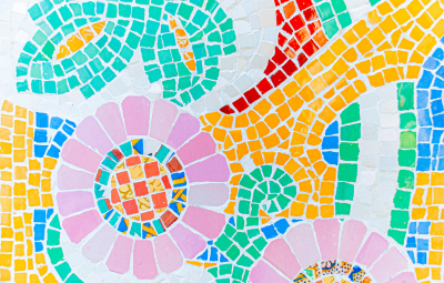 Colorful mosaic with pink flowers, yellow, green, red, and blue geometric tile patterns on a white background.