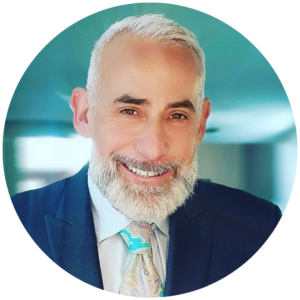 Smiling man with a beard in a suit and a colorful tie.